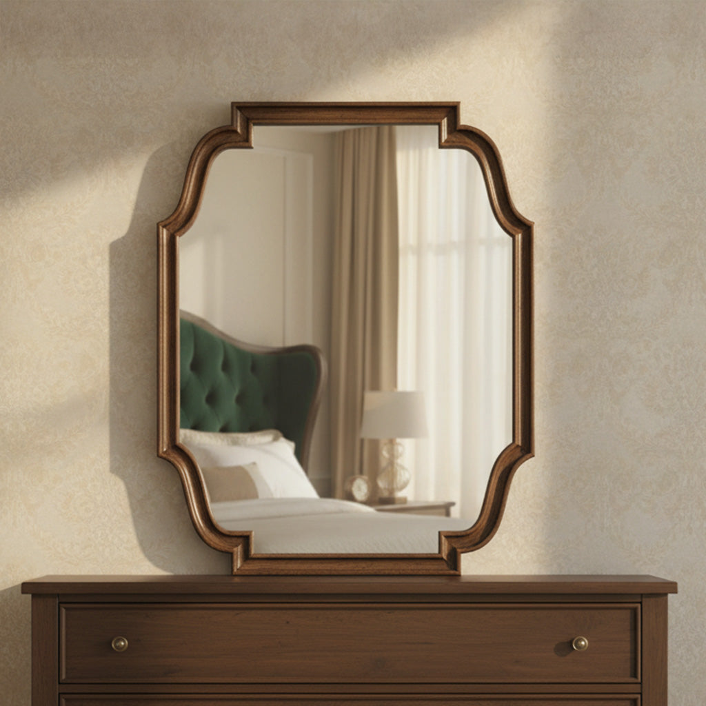 Carved wood framed Wexford mirror with beveled glass and black glaze finish hanging above dark wood dresser