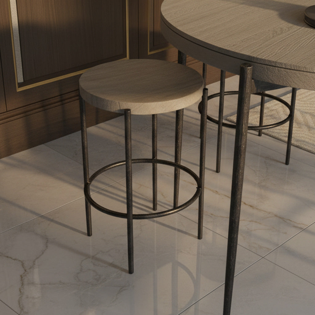 Round Bedford Park counter stool with light wood seat and black metal legs next to matching round pub table on marble floor