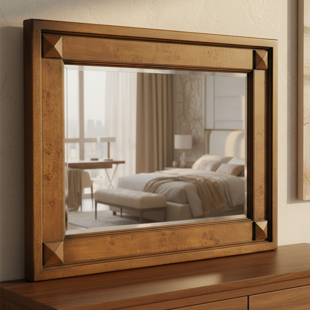 Square wooden wall mirror with decorative corner accents reflecting a cozy bedroom with bed and window light