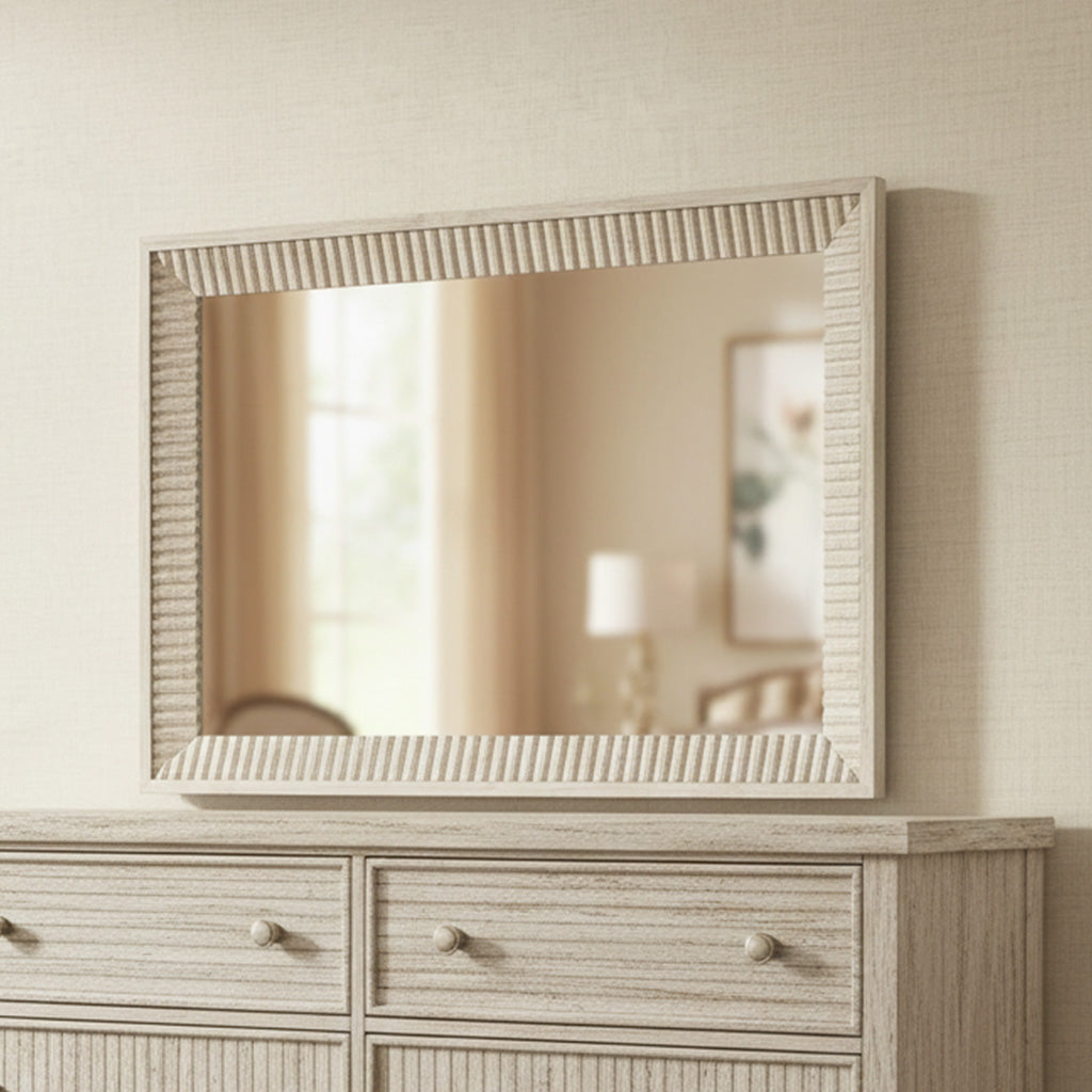 Rectangular wall mirror with serrated frame in Sierra finish above matching light wood dresser in neutral room