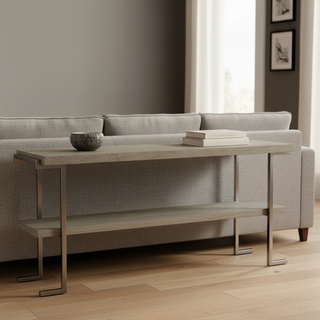 Light wood sofa table with stainless steel square legs, lower shelf, decorative bowl, and stacked books behind gray sofa