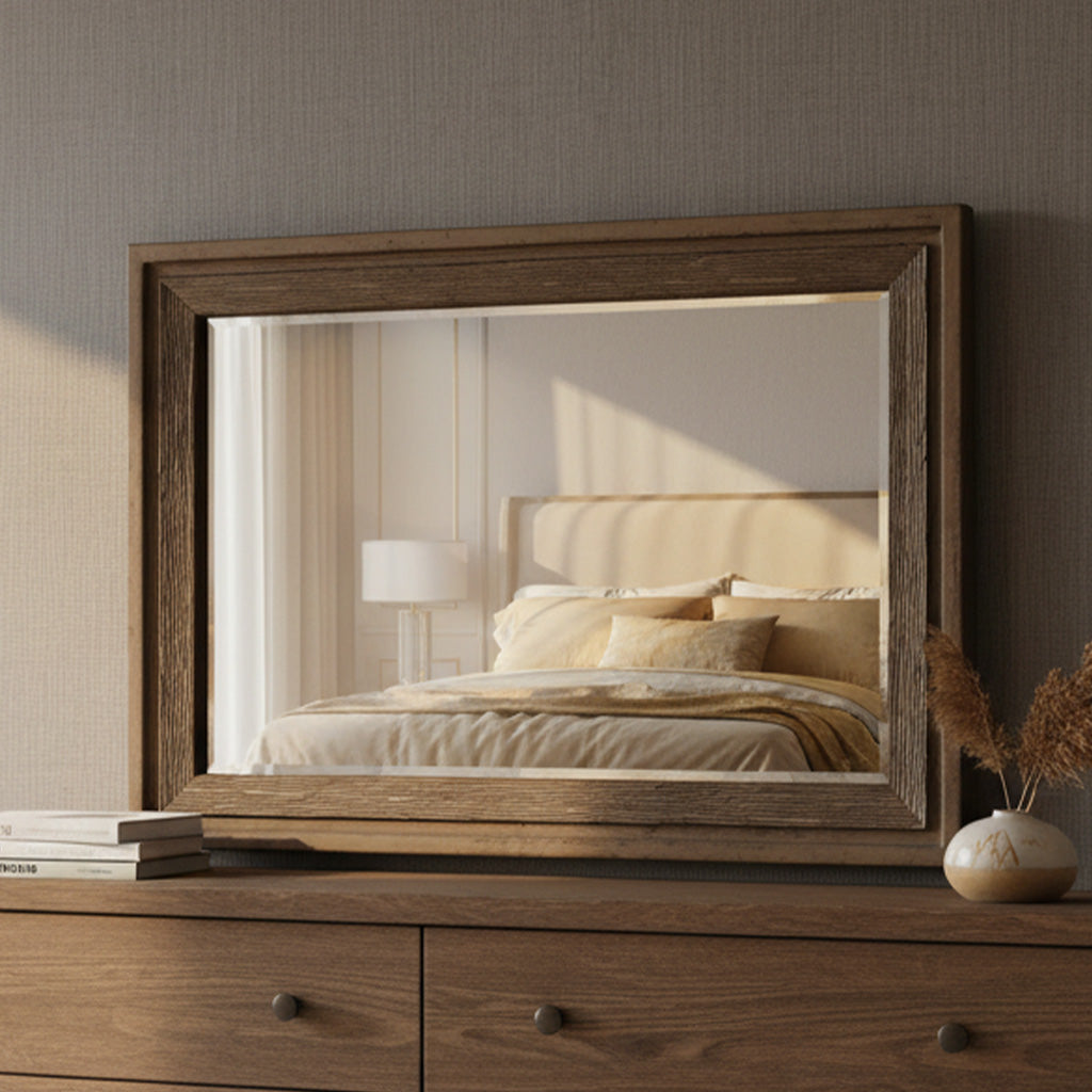 Beveled rectangular mirror with thick natural wood frame reflecting cozy bed, lamp, and neutral bedroom decor