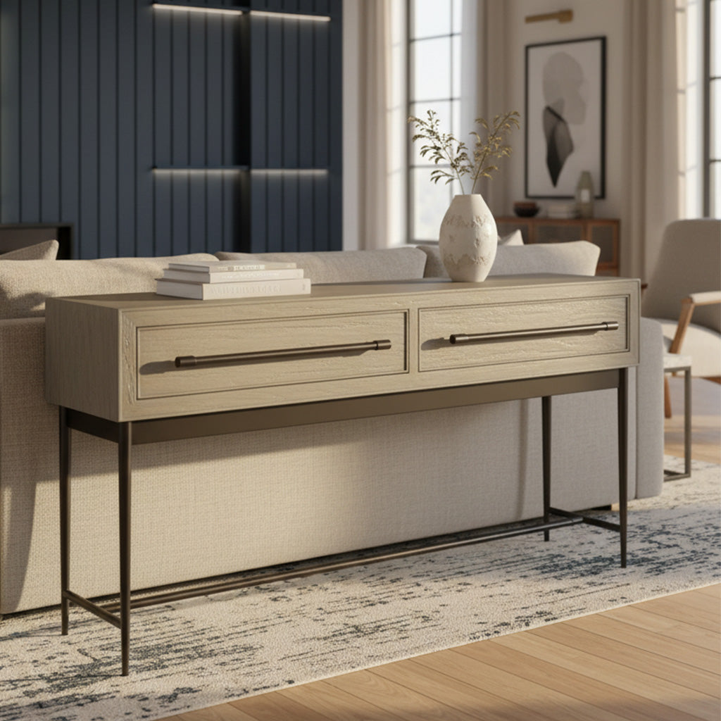 Light wood sofa table with two long antique brass bar drawer pulls, metal tapered legs, and decorative vase on top