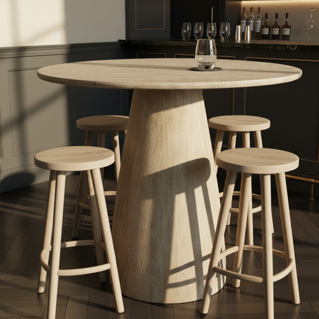 Round light wood pub table with solid pedestal base and four matching stools on dark wood floor in modern bar setting