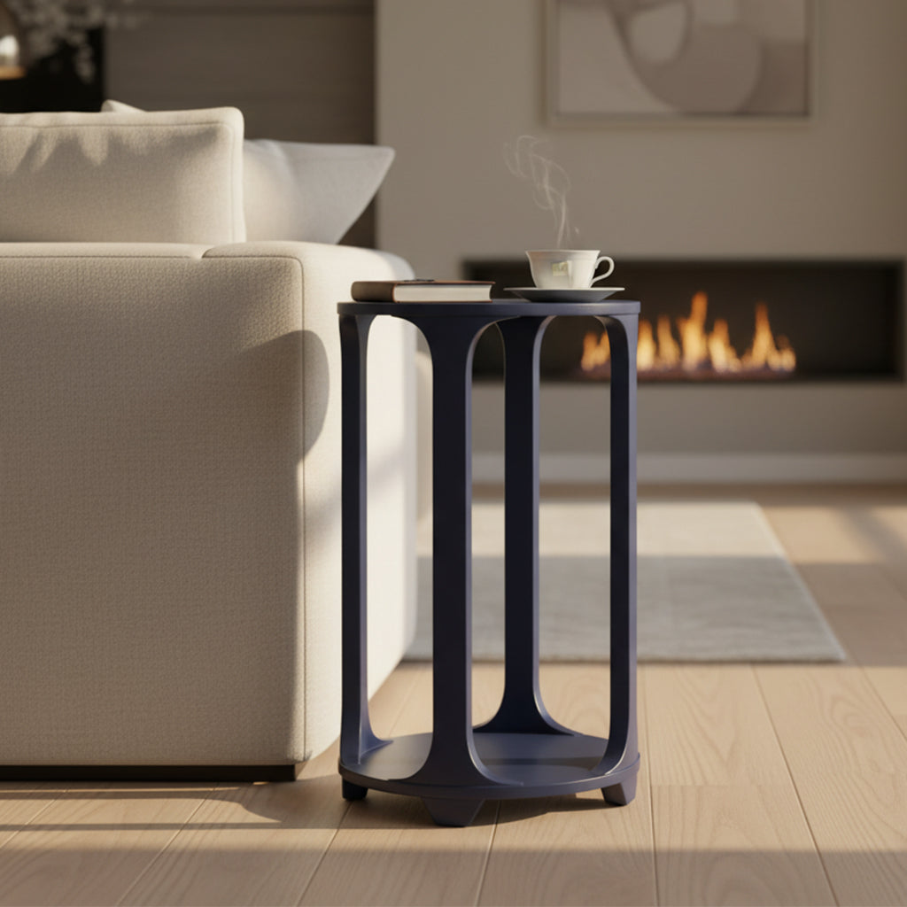 Round pedestal table with open design and smooth navy finish next to beige sofa in modern living room setting