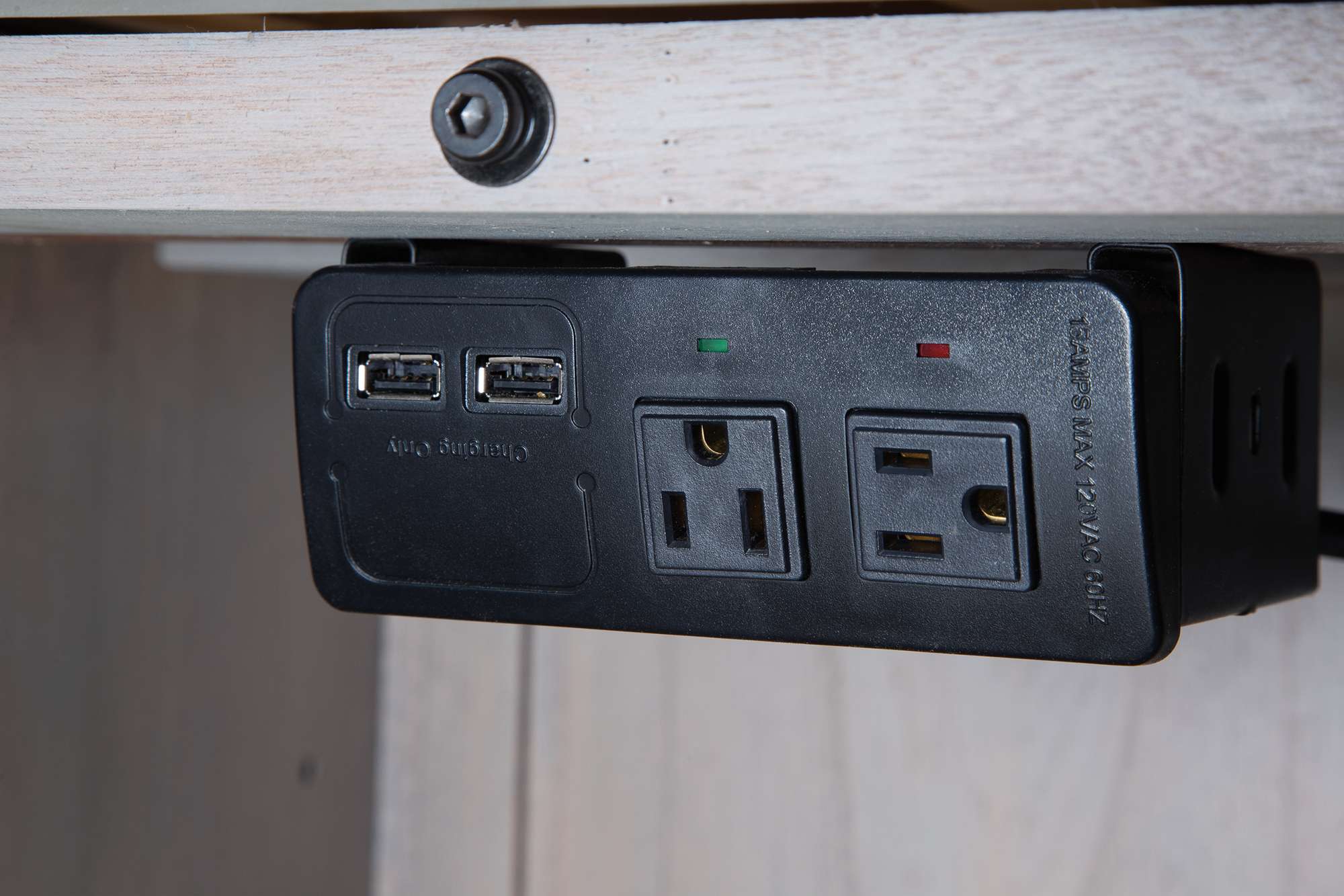 Power strip with dual USB ports and two electrical outlets mounted under driftwood finish office desk
